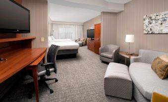a hotel room with a comfortable bed , a desk , a chair , and a tv . also a laptop on the desk at Courtyard Lufkin