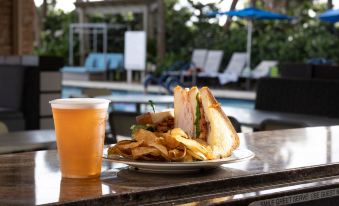 a plate of food and a cup of beer are placed on a bar next to a pool at Marriott's Oceana Palms