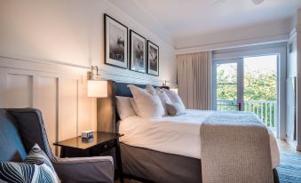 a cozy bedroom with a white bed , black headboard , and framed pictures on the wall at WaterSound Inn