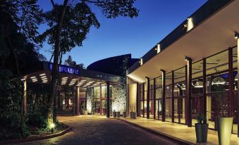 "a large building with a sign that reads "" events center "" is surrounded by trees and lit up at night" at Mercure Iguazu Hotel Iru
