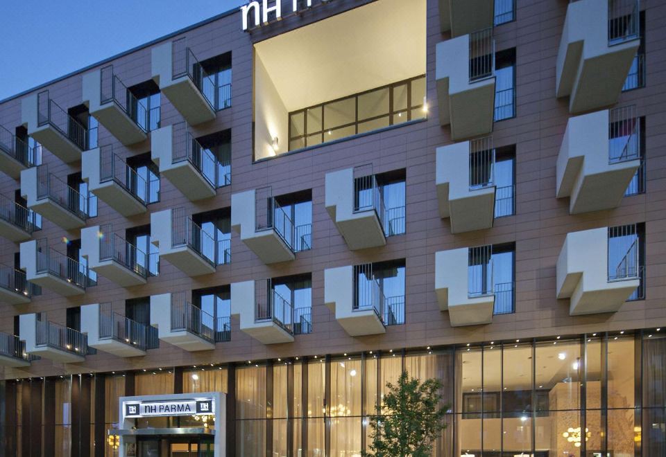 "a modern hotel with the name "" ah hotels "" displayed on the front of the building" at NH Parma