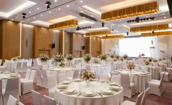 A ballroom is arranged for an event, with tables and chairs placed in the center at Holiday Inn & Suites Saigon Airport