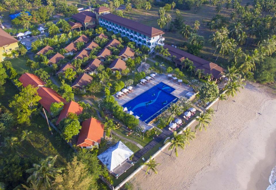 an aerial view of a resort with a swimming pool surrounded by palm trees and buildings at Kuiburi Hotel & Resort