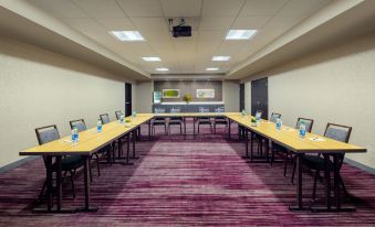 a large conference room with multiple long tables , chairs , and water bottles set up for meetings at Courtyard Dayton North