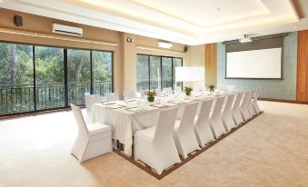 a long table with white chairs and tablecloths is set up in a conference room at The Farm at San Benito