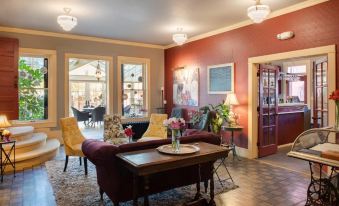 a cozy living room with red walls , wooden floors , and a coffee table in the center at Chamberlin Inn