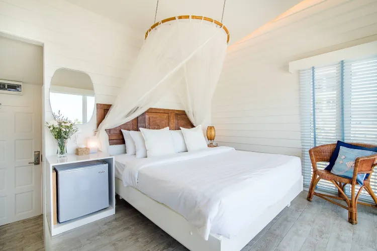 ห้องนอนหนึ่งห้องพร้อมระเบียงและวิวทะเล