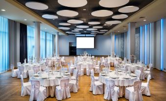 a large dining room with round tables and chairs set up for a formal event at Park Inn by Radisson Katowice