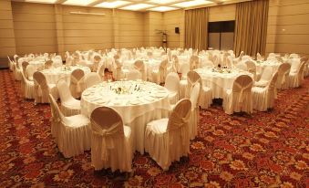 a large banquet hall is set up for a formal event , with tables and chairs arranged in an orderly fashion at DiplomaticHotel