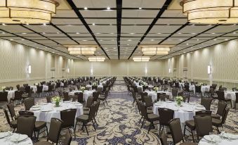 a large banquet hall filled with round tables and chairs , ready for a formal event at Delta Hotels by Marriott Baltimore Hunt Valley