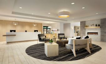 a modern hotel lobby with various seating options , including couches , chairs , and a dining table at Homewood Suites by Hilton Salt Lake City Draper