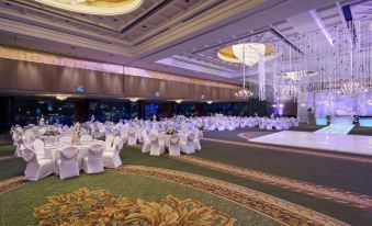 a large banquet hall filled with tables and chairs , where a wedding reception is taking place at Grand Nile Tower