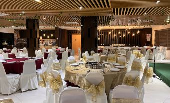 a large banquet hall filled with tables and chairs , ready for a formal event or a wedding reception at D Arc Hotel