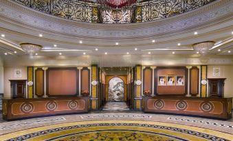 a grand foyer with a marble floor and a large chandelier hanging from the ceiling at Royal Rose Abu Dhabi