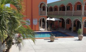 a courtyard with a swimming pool surrounded by a building , creating a serene and inviting atmosphere at Cactus Inn Los Cabos