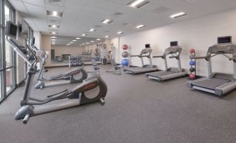 a gym with various exercise equipment , including treadmills and stationary bikes , arranged in a spacious room at Courtyard Austin Pflugerville and Pflugerville Conference Center