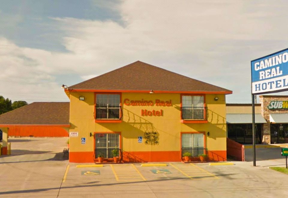 "a yellow and orange building with the words "" comfort inn "" written on it , located in a parking lot" at Camino Real Hotel