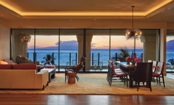 a modern living room with a large window overlooking the ocean , creating a serene and inviting atmosphere at Four Seasons Resort Maui at Wailea