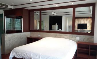 a large , well - made bed is in a room with wooden floors and a flat - screen tv mounted on the wall at Rawanda Resort Hotel