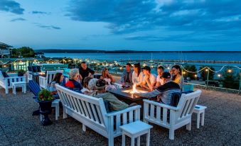 a group of people gathered around a fire pit on a rooftop , enjoying each other 's company at Oak Island Resort & Conference Centre