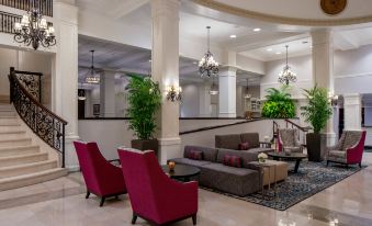 a modern hotel lobby with red chairs , gray couches , and green plants , creating a welcoming atmosphere at Hilton Garden Inn Jackson Downtown