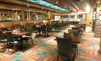 a large , well - lit dining room with multiple tables and chairs arranged for a group of people at Ute Mountain Casino Hotel