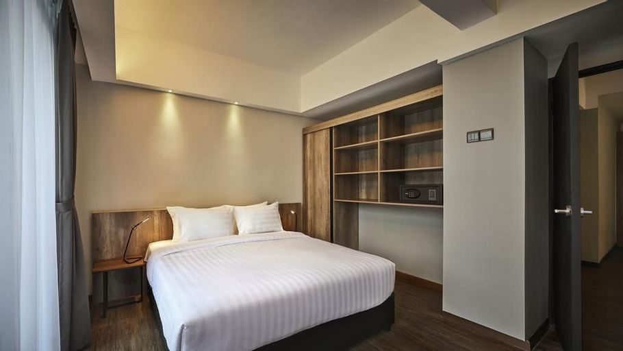 a large bed with white sheets is in a room with wooden shelves and lights at Tropics Eight Suites