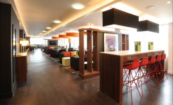 a modern , well - lit waiting area with wooden floors and white walls , featuring comfortable seating arrangements and comfortable seating arrangements at Hampton by Hilton Birmingham Broad Street