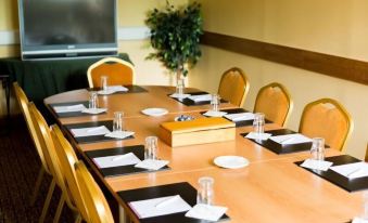 a conference room set up for a meeting , with a table and chairs arranged in a rectangular formation at Station House Hotel Letterkenny