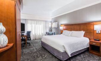 a modern hotel room with a white bed , wooden headboard , and gray carpet , along with other amenities at Courtyard Danbury