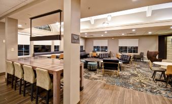 a modern office space with wooden floors , white walls , and large windows , featuring comfortable seating arrangements and a dining area at Residence Inn Dayton Beavercreek