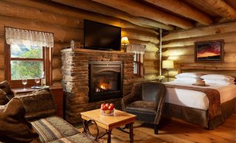 a cozy living room with a fireplace , wooden furniture , and a tv mounted on the wall at Justin Trails Resort