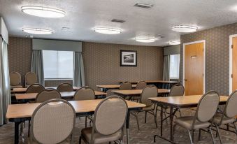 a conference room with chairs arranged in rows and a projector on the wall , providing bright light at Best Western Space Shuttle Inn