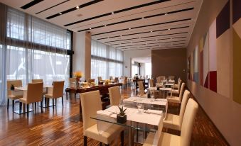 a large dining room with multiple tables and chairs arranged for a group of people to enjoy a meal together at Devero Hotel  Spa, BW Signature Collection