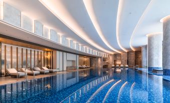 The interior of the hotel includes a spacious pool and an indoor spa with floor-to-ceiling windows at Joyhub Air Hotel