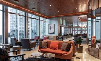 a modern hotel lobby with various seating options , including couches , chairs , and a coffee table at The Charter Hotel Seattle, Curio Collection by Hilton