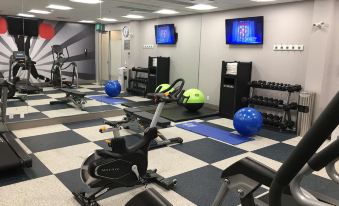 a well - equipped gym with various exercise equipment , including a treadmill , stationary bike , and weights at GLo Best Western Kanata Ottawa West