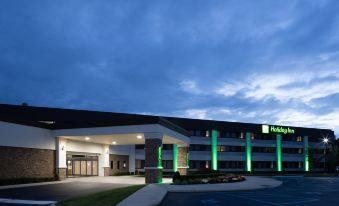 a large hotel with a green and white color scheme , located in a residential area at Holiday Inn Long Island - Islip Arpt East