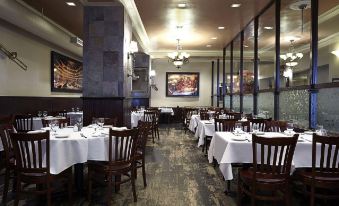 There is a restaurant in the dining room area with tables and chairs, as well as an open door at Hotel Pennsylvania