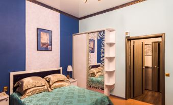 a bedroom with blue walls , a white ceiling fan , and a bed with blue bedding at Diana