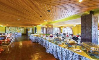 a long dining table filled with a variety of food items , creating a festive atmosphere at Rainbow Ruiru Resort
