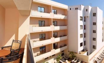 a hotel with multiple balconies and a large pool area , providing a pleasant outdoor space for guests to relax at Invisa Hotel la Cala