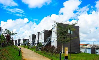 a row of modern houses with a blue sky and clouds in the background , along with a pathway leading to them at Lakeview Terrace Resort Pengerang