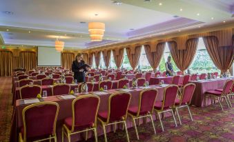 a large conference room filled with rows of chairs arranged in a semicircle , ready for a meeting or event at The Inn at Dromoland