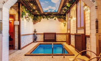 a small indoor swimming pool surrounded by wooden walls , with a lounge chair placed in front of it at Voyage