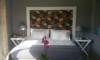 a bed with a floral headboard and white linens is shown in a hotel room at Upper House Guesthouse