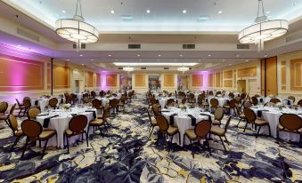 a large banquet hall filled with round tables and chairs , ready for a formal event at DoubleTree Boston North Shore Danvers