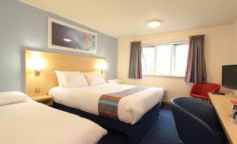 a hotel room with three beds , two of which are twin beds and one is a double bed at Travelodge Nottingham Trowell M1