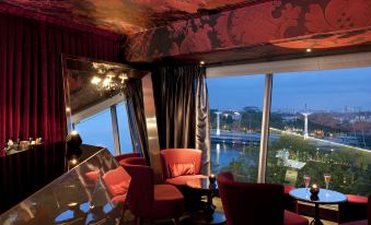 a modern room with a red couch , black curtains , and a view of the city at Sofitel Lyon Bellecour