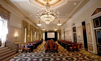 a large conference room with multiple rows of chairs arranged in a semicircle , creating an auditorium - like setting at Bourbon Orleans Hotel